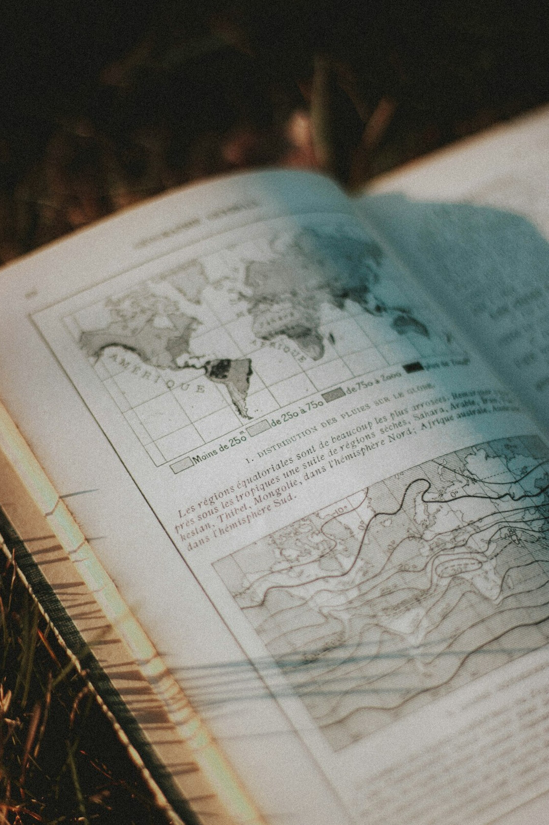 Open antique book with a magnifying glass and an old map