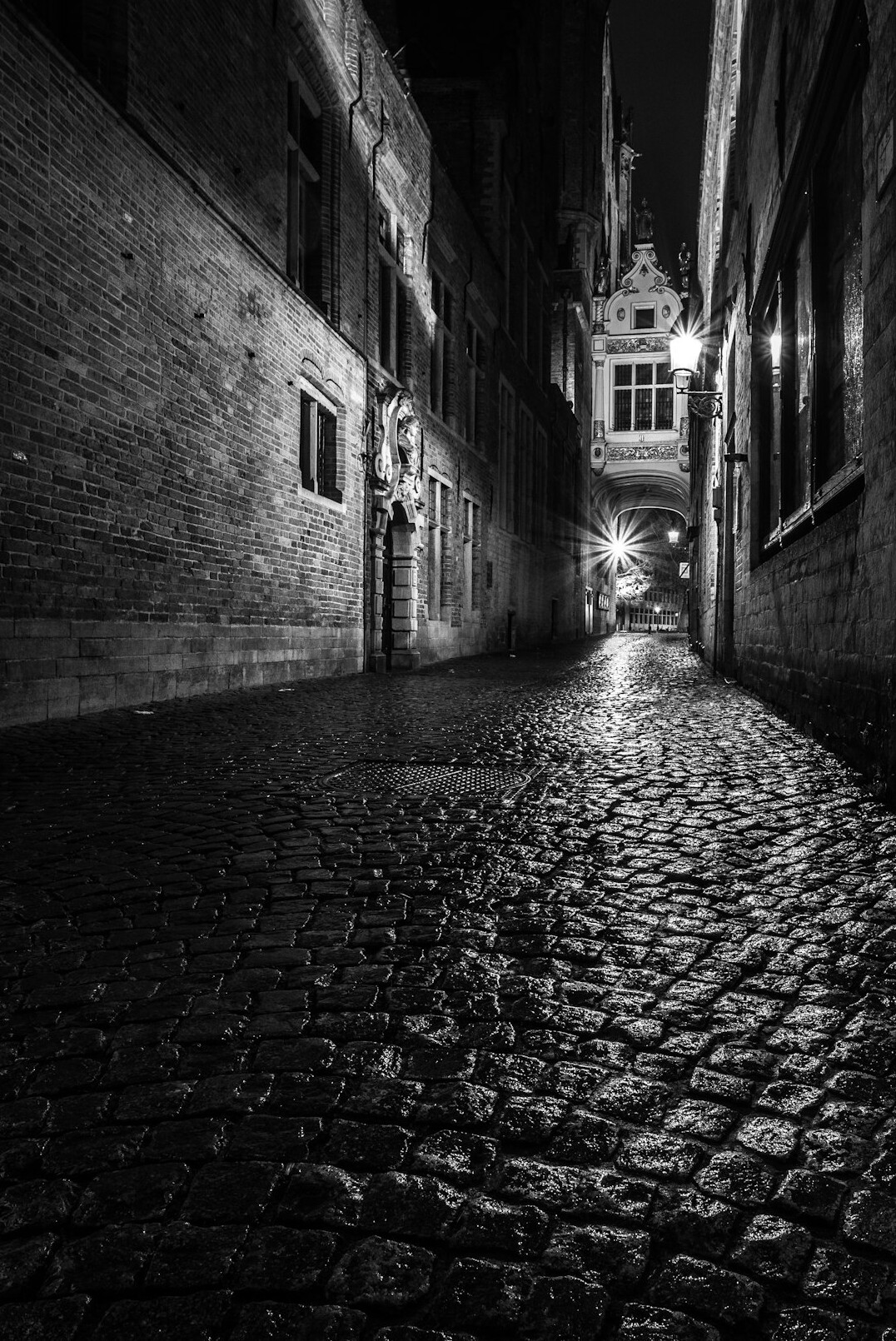 Dark cobblestone street at dusk with old buildings
