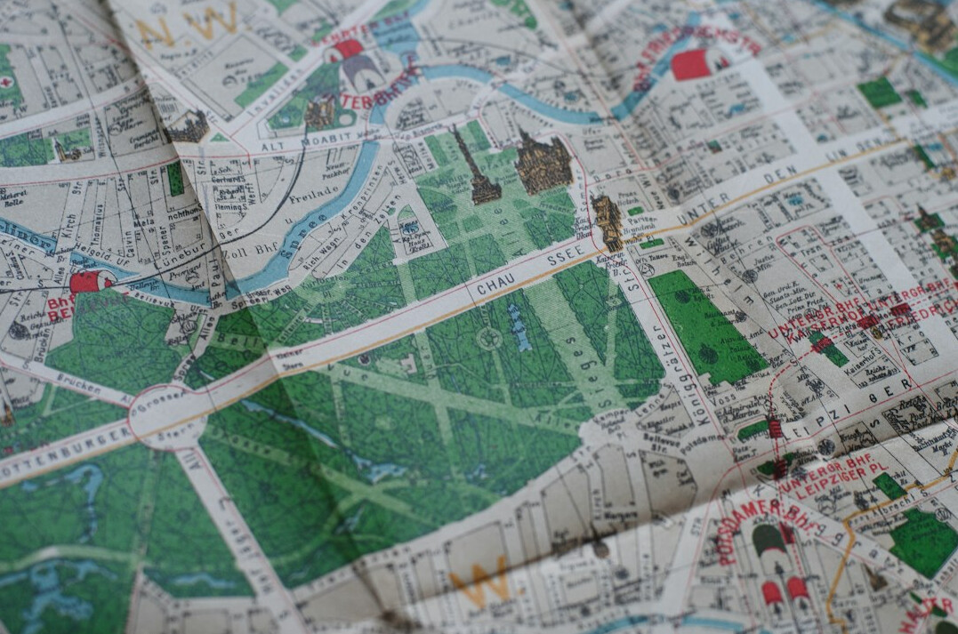 Old folded city map with pins and string